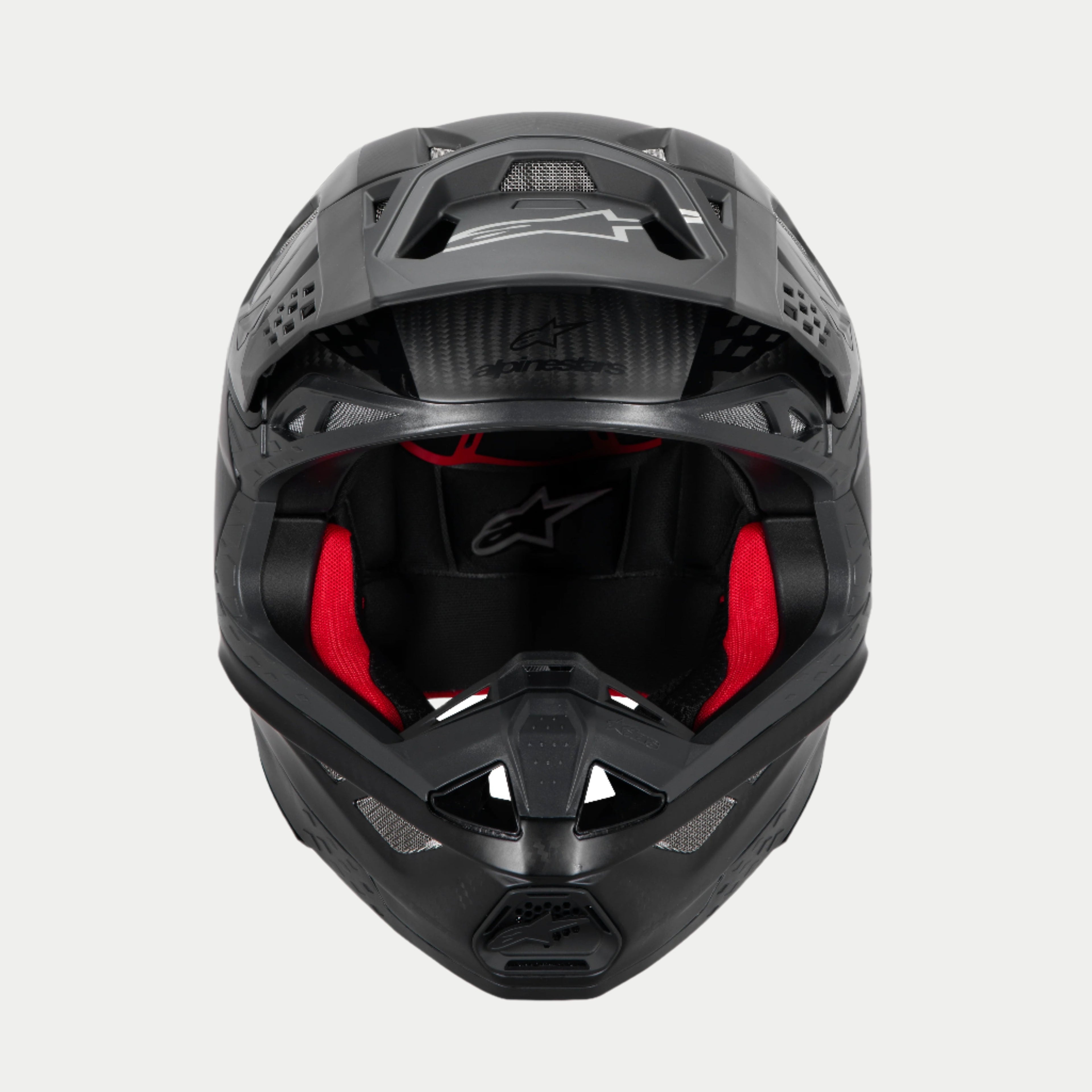 Alpinestars Supertech M10 Fame ECE 22.06 Helmet, Motocross Helmet, Black Carbon Matte and Glossy, front view with visible red interior padding, aerodynamic carbon fiber shell, ventilated design for off-road racing
