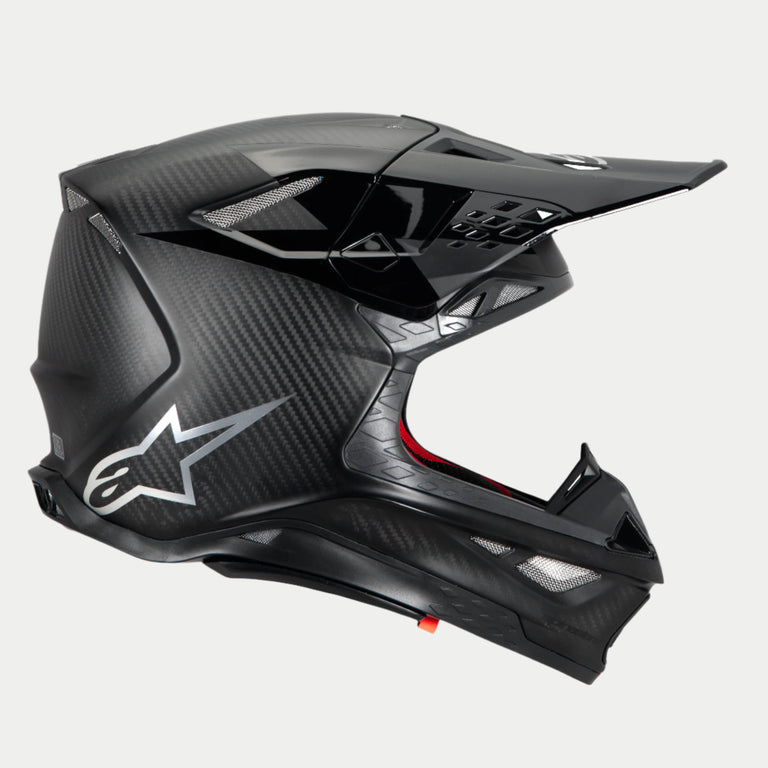 Alpinestars Supertech M10 Fame Helmet, Motocross Helmet, Black Carbon Matte and Glossy, side profile highlighting carbon fiber weave and silver Astars logo, aerodynamic design with multiple mesh-covered ventilation ports, high-performance off-road head protection