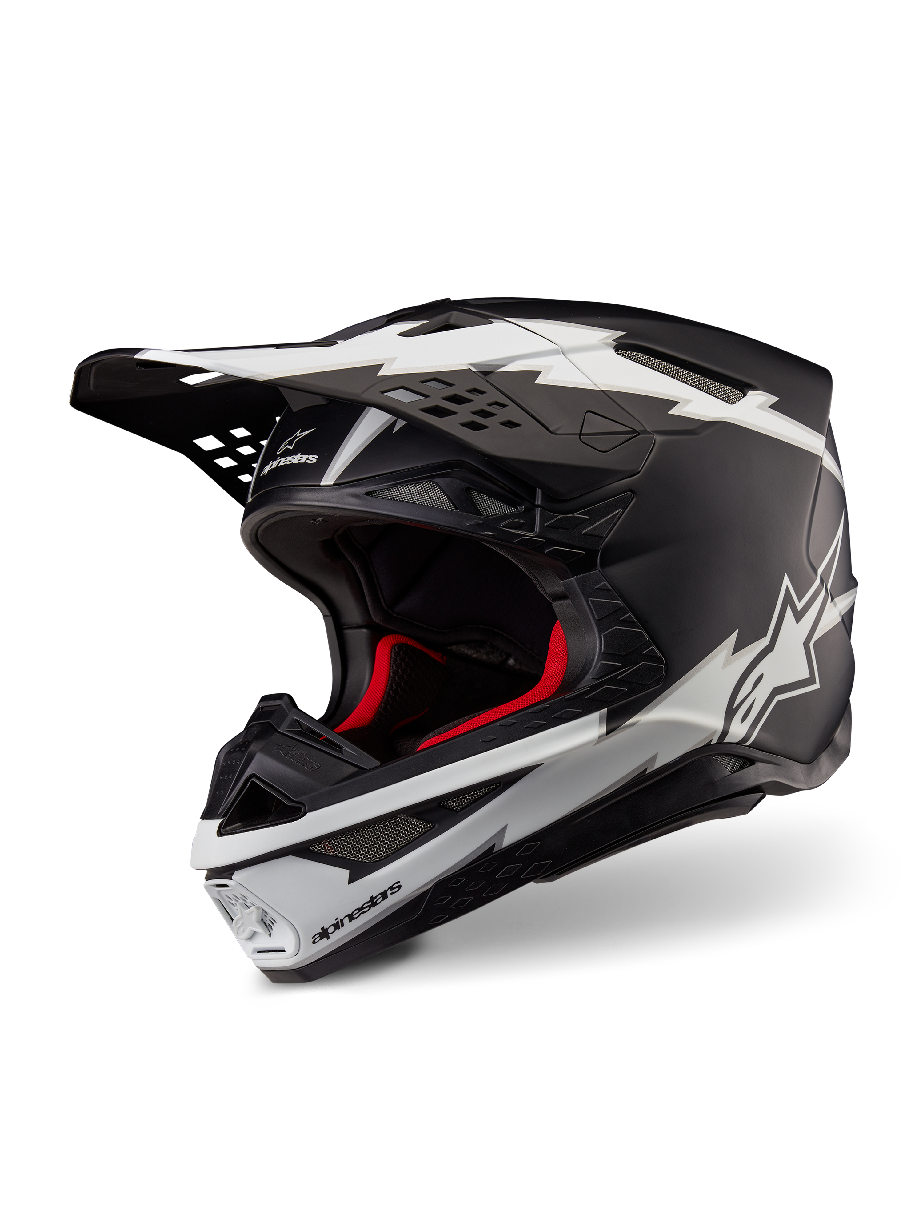 Alpinestars Supertech M10 Ampress Helmet, Motocross Helmet, Matte Black and White, featuring bold white lightning-style graphics and star logos, red internal lining, multi-composite carbon shell with a streamlined aerodynamic profile