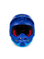 Alpinestars Supertech M10 Flood Helm ECE, Motocross-Helm, Metallic- und Mittelblau mit schwarzen Carbon-Akzenten, Vorderansicht mit Kinnbügel und Sichtfeld, weiße Alpinestars-Logos und Schriftzüge, rote Innenpolsterung, professioneller Offroad-Schutz