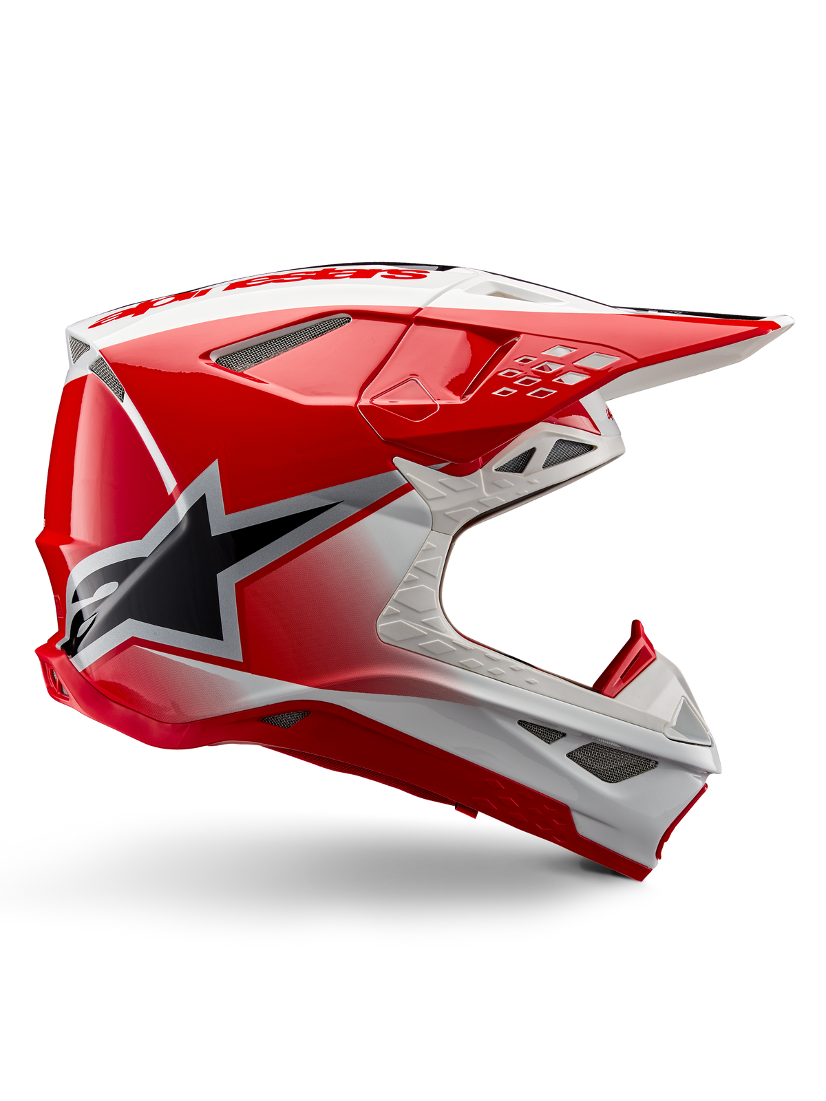 Alpinestars Supertech M10 Unite Helm, Motocross-Rennhelm, Rot und Weiß glänzend, Seitenansicht mit eckigen geometrischen Mustern, schwarze Stern-Grafik, mehrere Mesh-Belüftungsöffnungen, aerodynamisches Design für Offroad-Rennsport