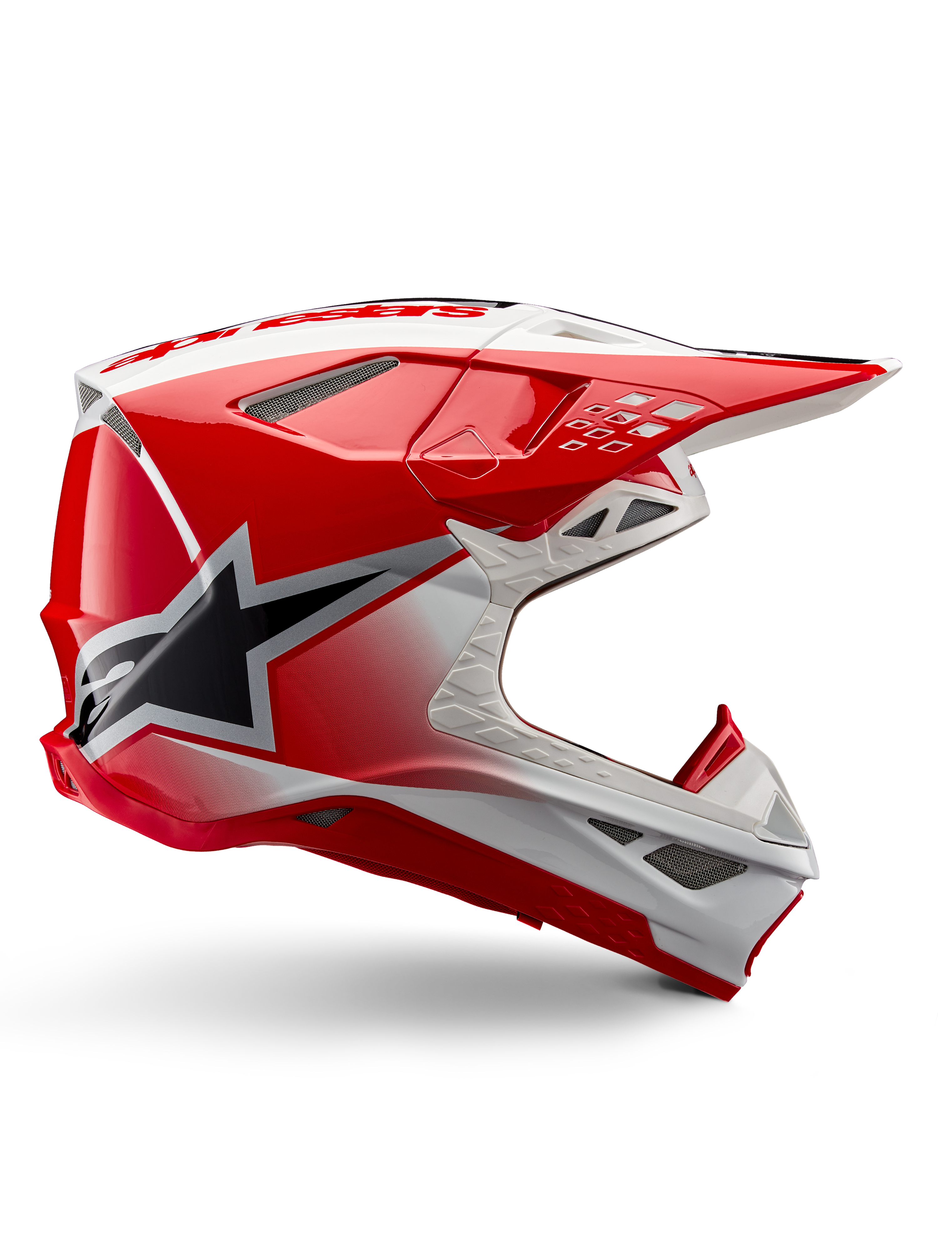 Alpinestars Supertech M10 Unite Helm, Motocross-Rennhelm, Rot und Weiß glänzend, Seitenansicht mit eckigen geometrischen Mustern, schwarze Stern-Grafik, mehrere Mesh-Belüftungsöffnungen, aerodynamisches Design für Offroad-Rennsport