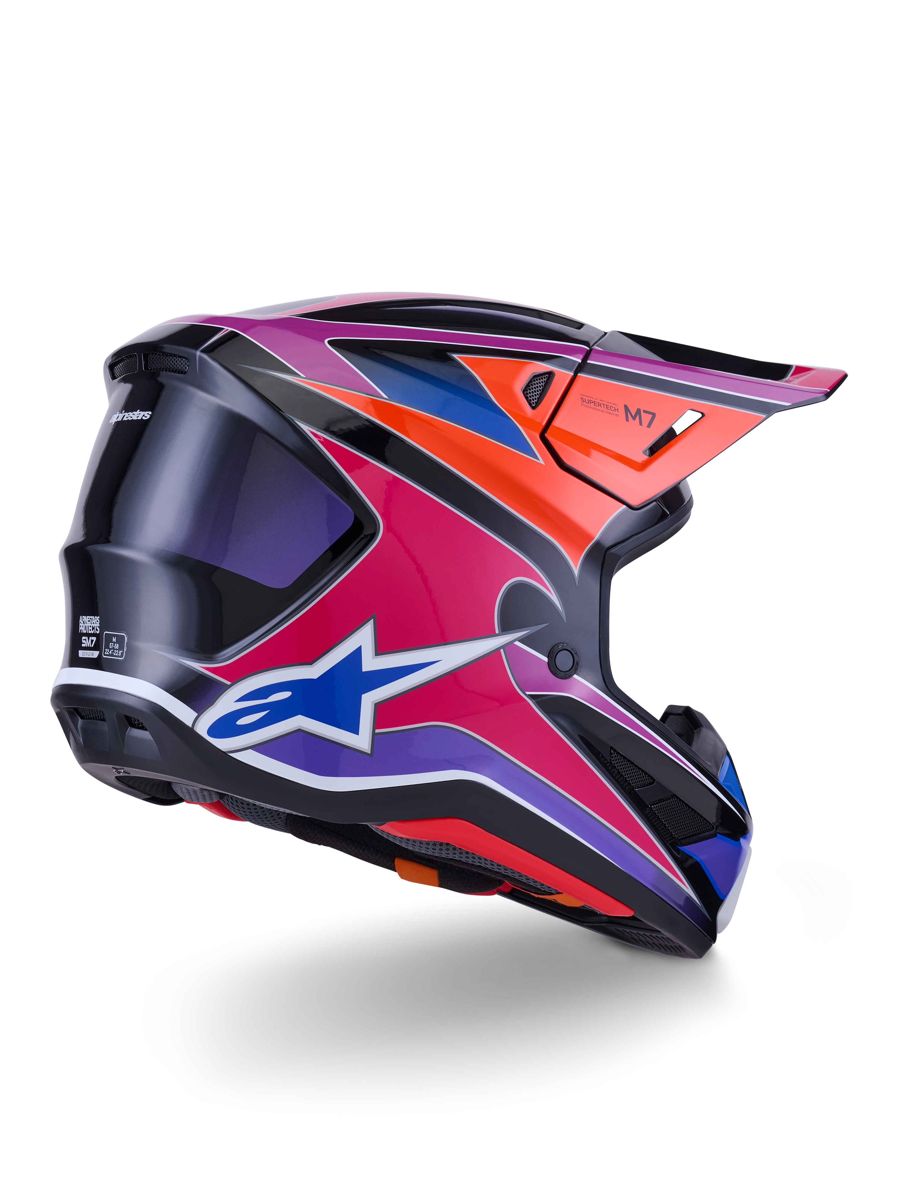 Alpinestars S-M7 Fuse Helm, Motocross-Helm, Blau, Lila und Pink glänzend mit orangefarbenen und schwarzen Akzenten, Dreiviertelansicht von hinten zeigt die aerodynamische Schale, das Visier und die Belüftungsöffnungen, professioneller Schutz für den Offroad-Rennsport