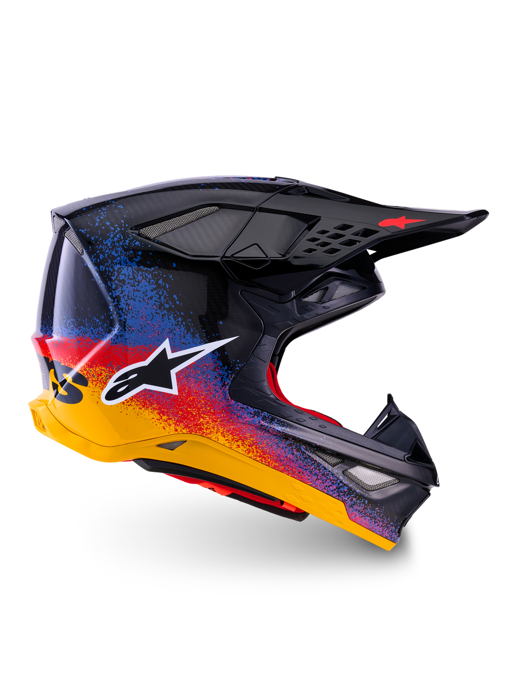 Alpinestars Limited Edition Supertech M10 Black Hole Helm, Motocross-Rennhelm, schwarze Schale mit rot-blau-gelbem Splatter-Farbverlauf, weißes Stern-Logo auf der Seite, aerodynamisches Profil mit netzabgedeckten Belüftungsöffnungen, rote Innenpolsterung und langes schwarzes Visier.