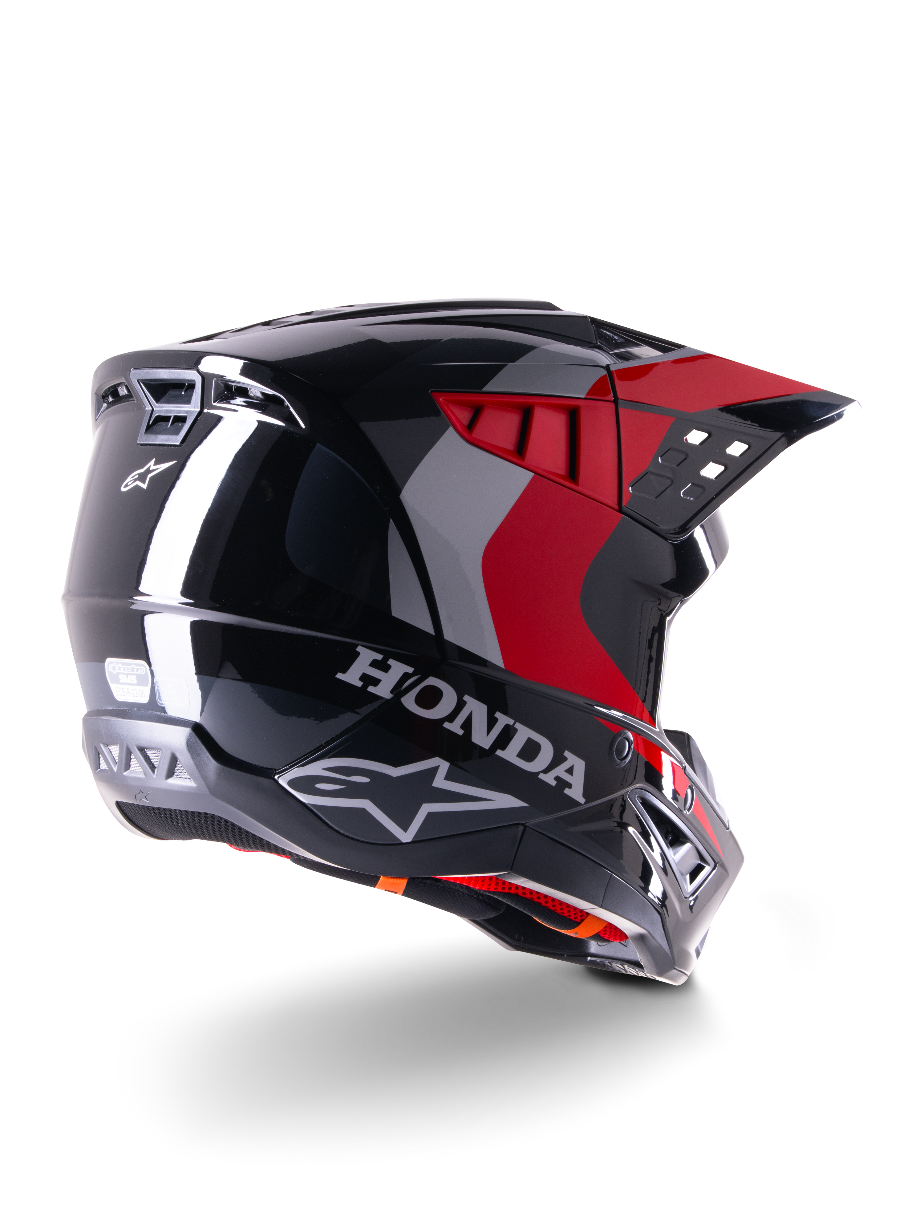 Alpinestars Honda S-M5 Helm ECE, Motocross-Helm, Schwarz Rot Glänzend, Rückansicht in Dreiviertel-Perspektive mit Honda-Branding und Alpinestars-Logos, glänzendes Finish mit roten und grauen Grafikakzenten, entwickelt für Offroad-Schutz