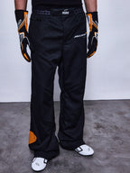RSRV Arena Suit Pants, Schwarze Rennhose, McLaren und Alpinestars Logos, Orange Patches an der Seite, Orange Kniedetail, Motorsport-Performance-Hose