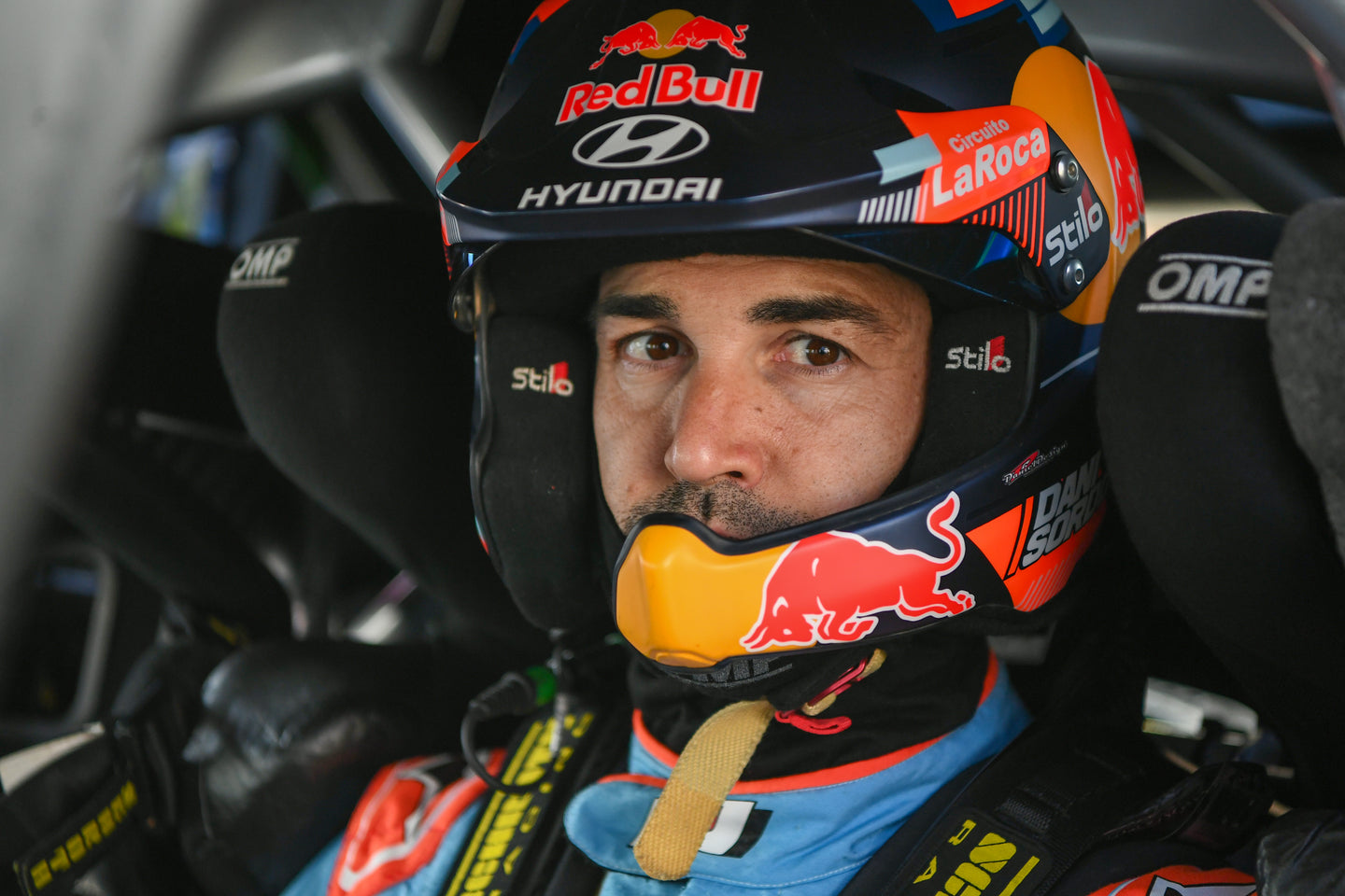 Close up shot of Dani Sordo in his Rally car, clothed with an Alpinestars suit