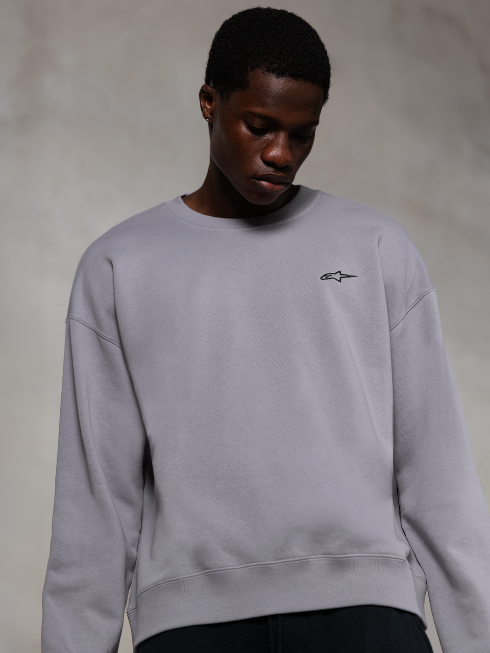 Alpinestars Essentials Ageless Crew, Silver premium crewneck sweatshirt, featuring a small black Alpinestars logo on the chest, worn by a model, casual lifestyle streetwear with a soft fleece texture.