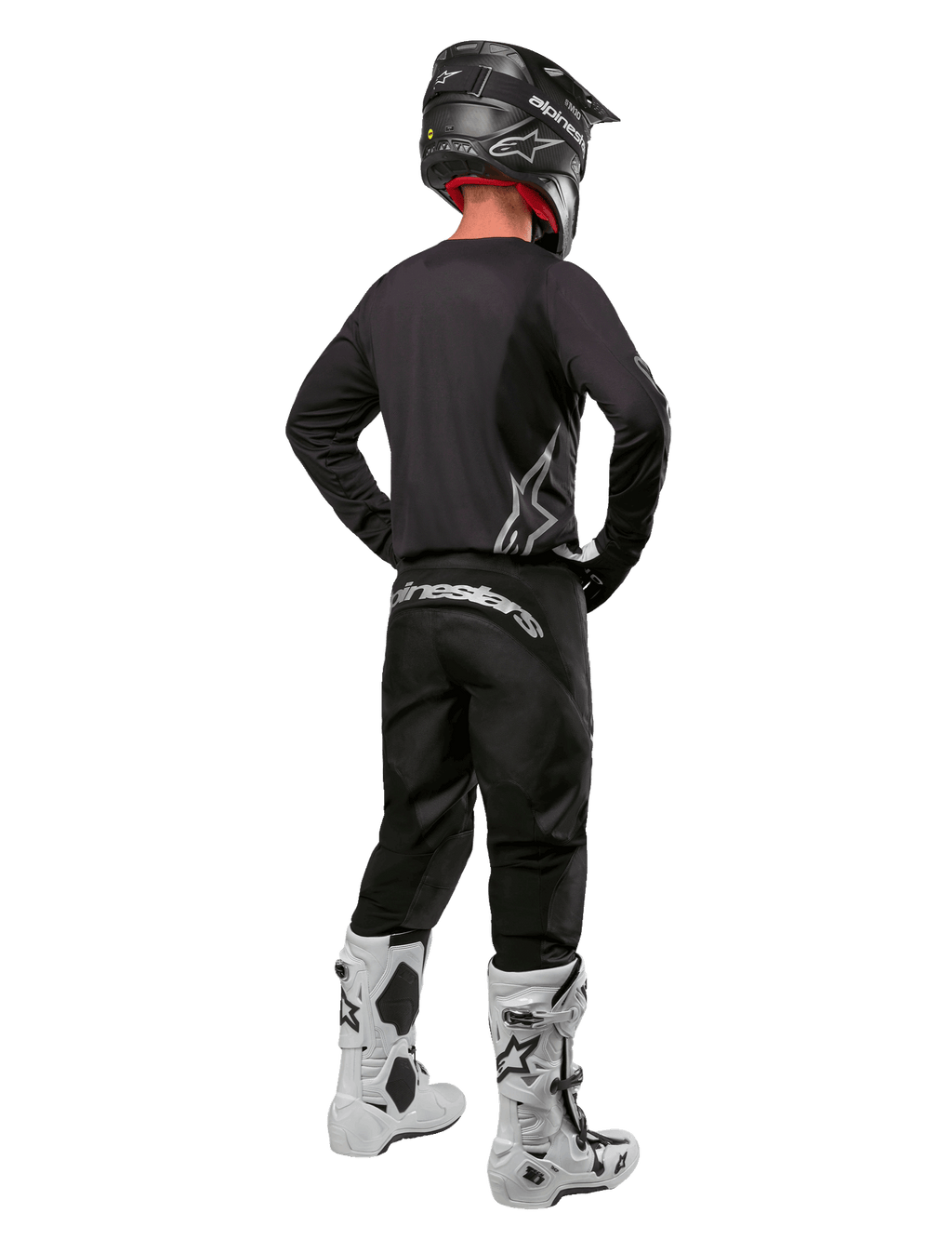 Alpinestars 2024 Fluid Graphite Gear Set, Motocross-Fahrer in der Rückansicht, graphitgraues Jersey und Hose mit silbernem Alpinestars-Branding, schwarzer Helm und weiße Motocross-Stiefel, athletische Passform für den Offroad-Einsatz