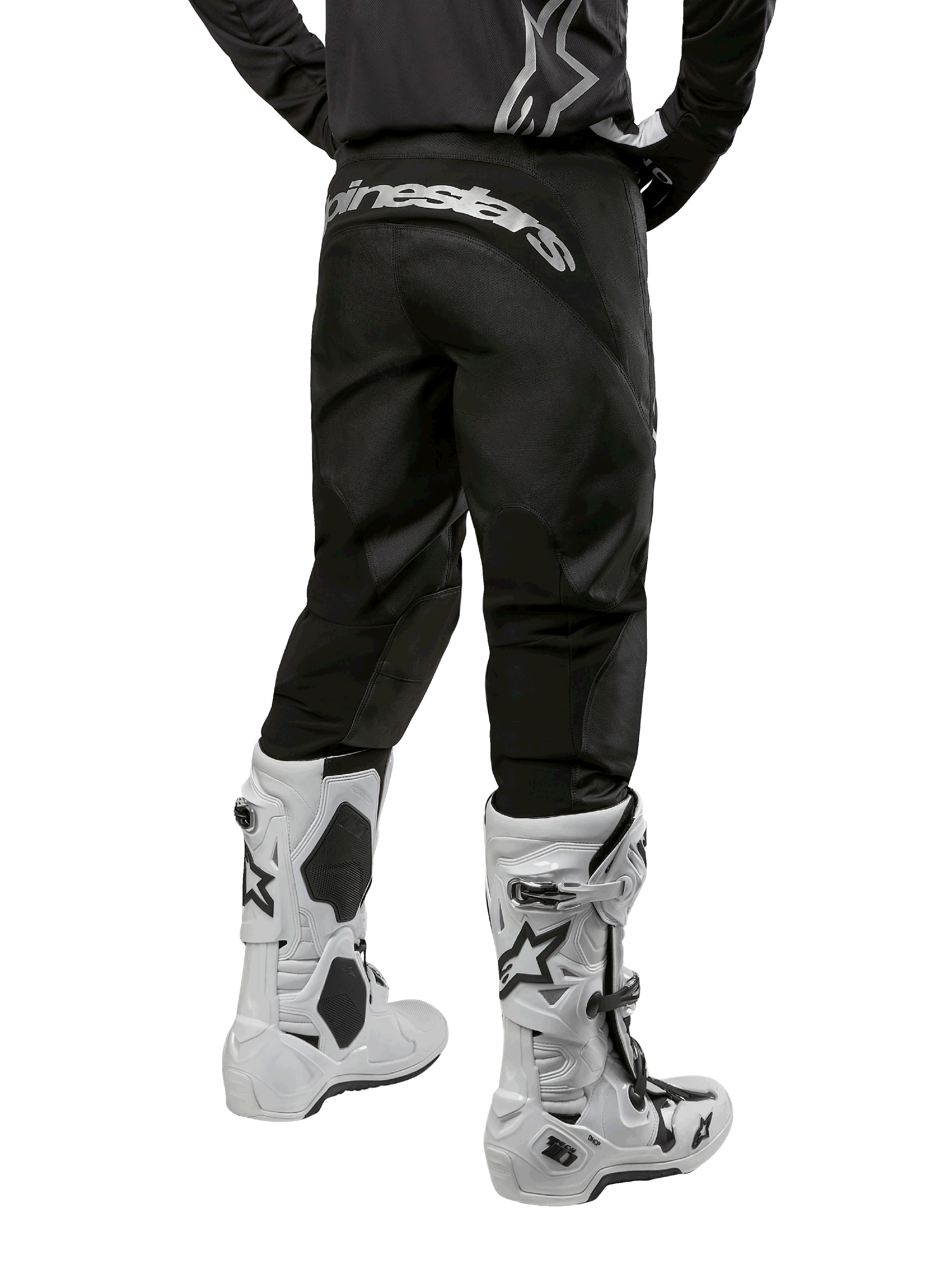 Alpinestars 2024 Fluid Graphite Ausrüstungsset, Rückansicht der schwarz-grauen Motocross-Hose mit weißem Alpinestars-Branding am Gesäß, weiße und schwarze Motocross-Stiefel, spezialisierte Offroad-Rennausrüstung