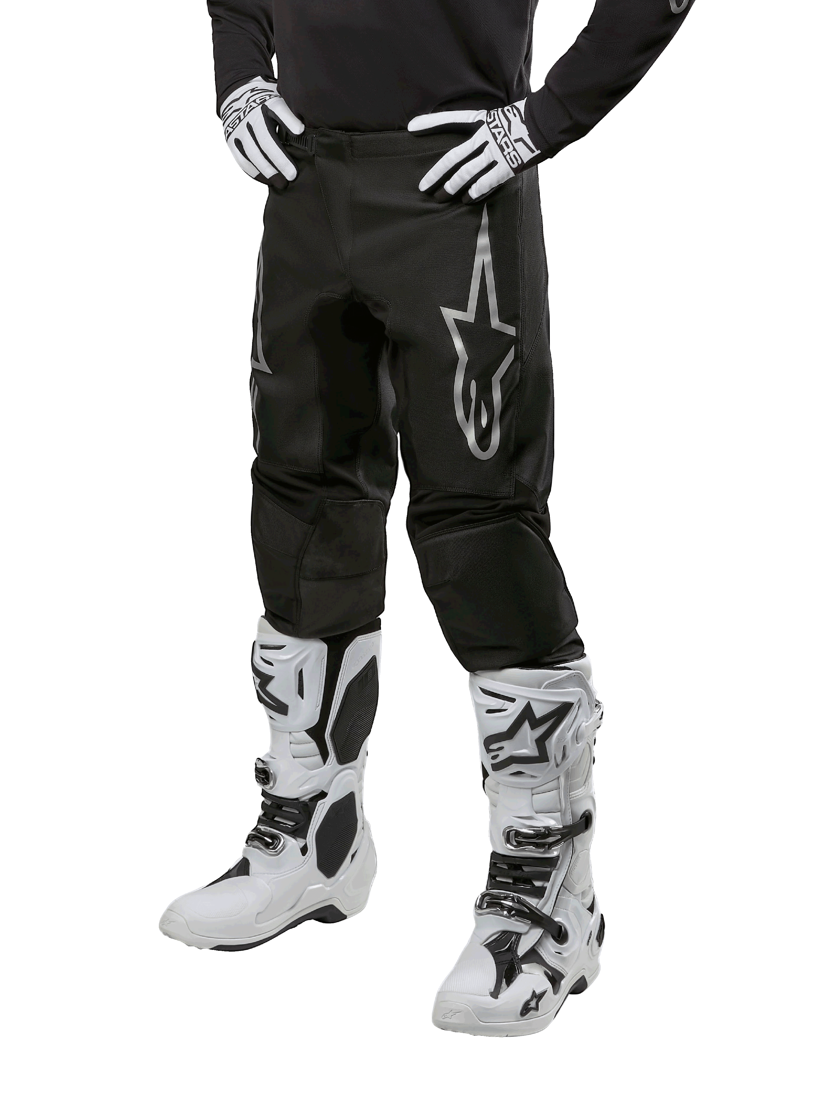 Alpinestars 2024 Fluid Graphite Hose, Motocross-Hose, Grau und Schwarz, kombiniert mit weiß-schwarzen Motocross-Stiefeln und Handschuhen, mit großem silbernen Alpinestars-Logo am Oberschenkel, sportlich-athletische Passform für Offroad-Fahrten