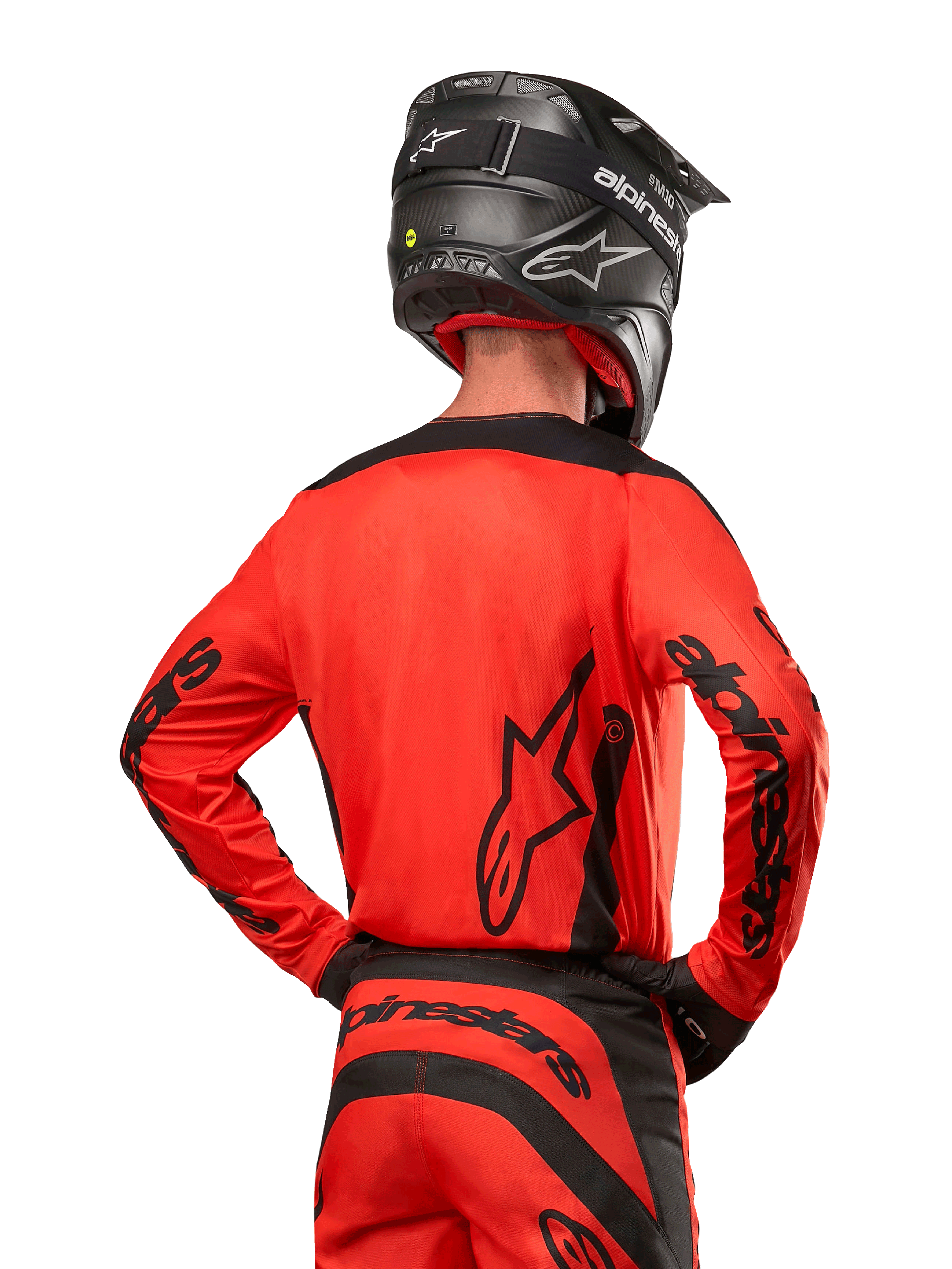 Motocross-Fahrer von hinten im Alpinestars 2024 Fluid Lurv Trikot in Hot Orange und Schwarz, mit auffälligem Alpinestars-Branding auf dem Rücken und den Ärmeln, kombiniert mit passender Motocross-Hose und einem schwarzen Helm, entwickelt für Offroad-Rennsport-Performance.