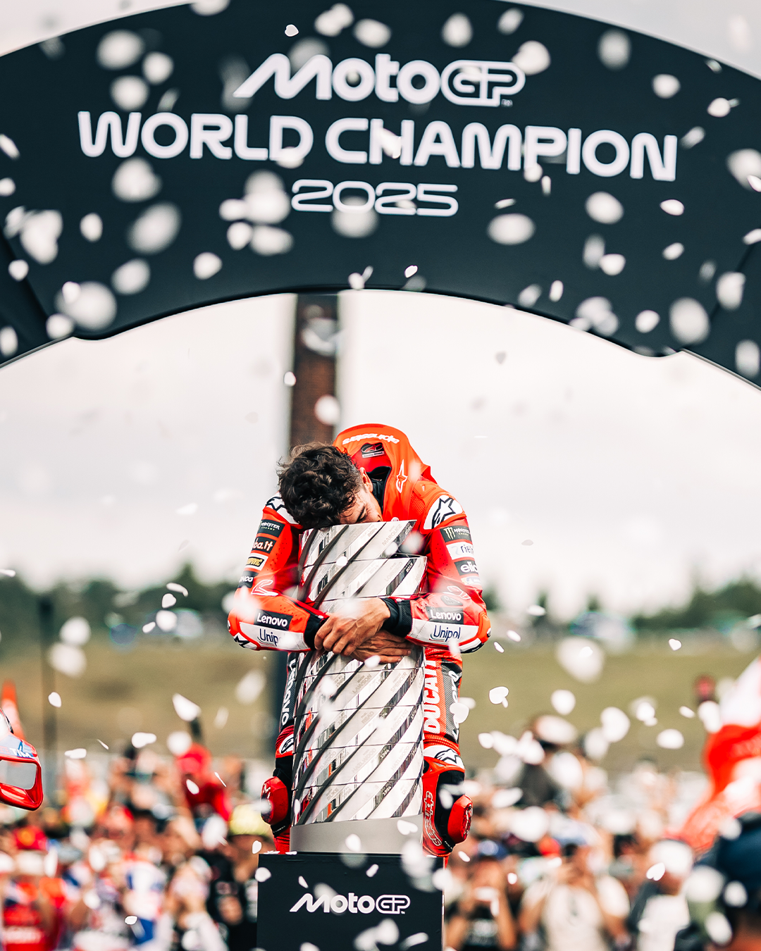 Marc Marquez celebrating the 2025 MotoGP win next to his Ducati