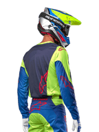 Motocross-Fahrer im Alpinestars 2024 Racer Hoen Trikot in Yellow Fluo und Blue Night Navy, mit einem roten Stern-Logo auf dem Rücken, passender Motocross-Hose und abgestimmtem Rennhelm, Rückansicht zur Darstellung des ergonomischen Designs für Offroad-Performance.