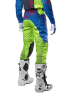 Alpinestars 2024 Racer Hoen Hose, Motocross-Hose, Gelb Fluo und Blau Night Navy, Rückansicht, mit rotem Alpinestars-Logo, getragen mit passendem Jersey, weißen Handschuhen und weißen Motocross-Stiefeln, strapazierfähiges Textil für Offroad-Rennsport