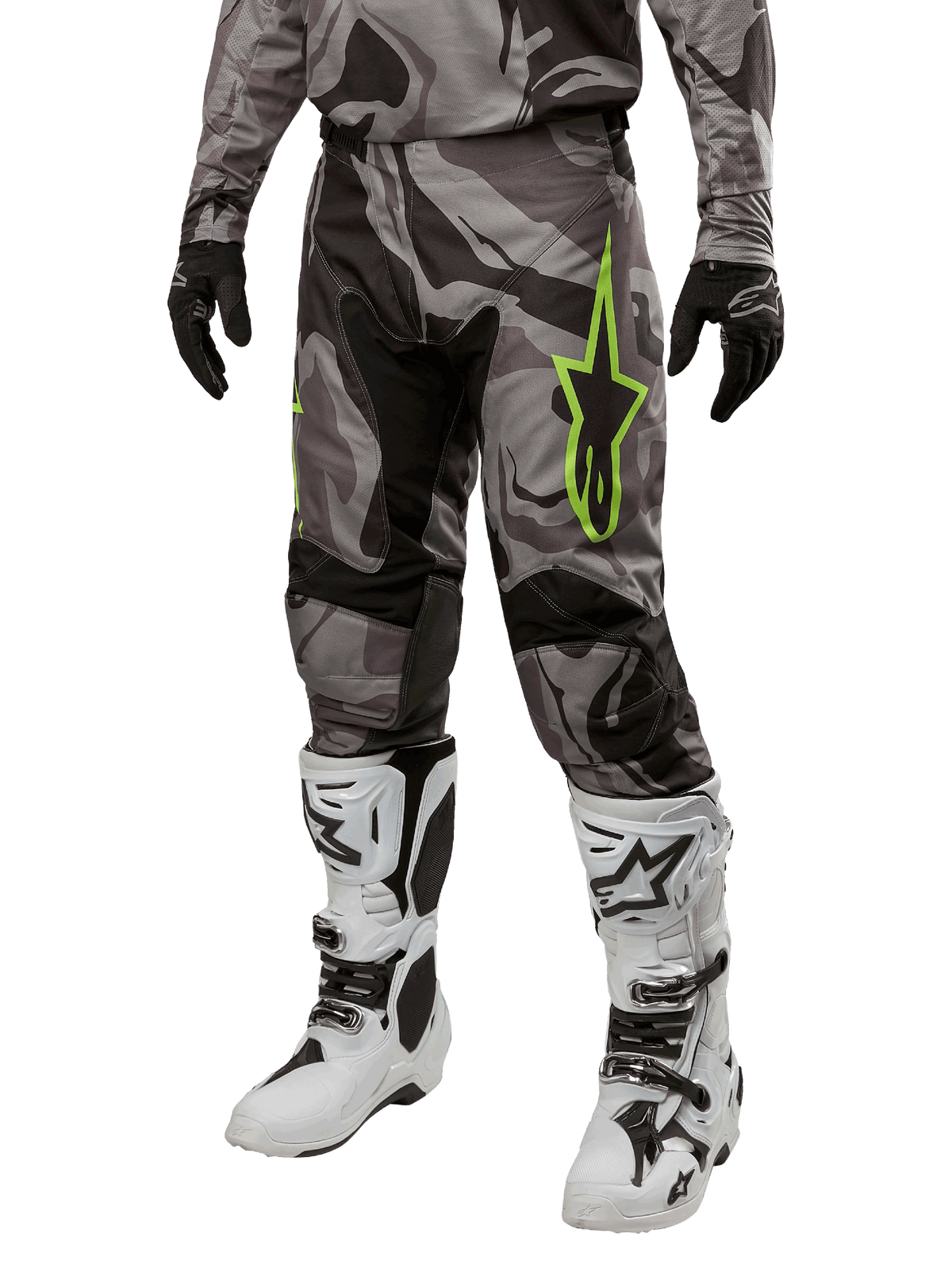 Alpinestars 2024 Racer Tactical Hose, Motocross-Hose, Grau und Schwarz Tarnmuster, neongrünes Stern-Logo, getragen mit weiß-schwarzen Stiefeln und schwarzen Handschuhen, Geländefahrt-Ausrüstung