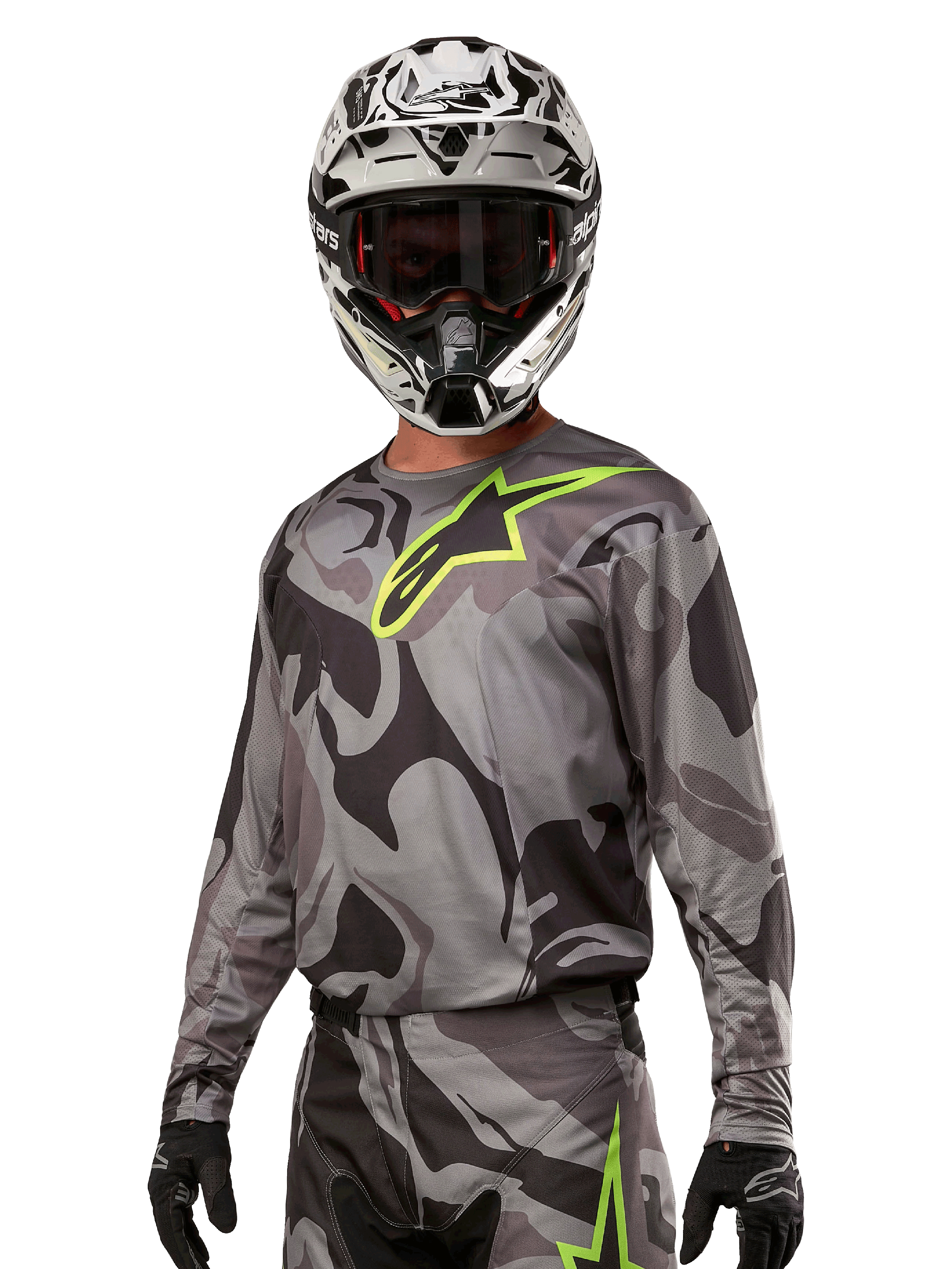 Alpinestars 2024 Racer Tactical Jersey, Motocross-Trikot, Cast Gray Camo Magnet mit neongrünem Logo, getragen mit schwarz-weißem Helm und schwarzen Handschuhen, technisches feuchtigkeitsableitendes Material für Offroad-Rennsport