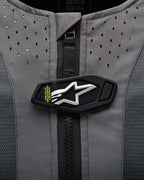Alpinestars Tech-Air 5 Airbag-System, magnetische Verschlussklappe mit weißem Stern-Logo auf grauem perforiertem Gewebe.