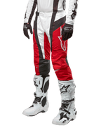 Alpinestars 2024 Techstar Ocuri Hose, Motocross-Rennsport-Hose, Mars-Rot, Weiß und Schwarz, getragen mit dazu passendem weiß-schwarzem Trikot, schwarzen Handschuhen und weißen Rennstiefeln mit Schnallen, technische Schutzausrüstung auf weißem Hintergrund