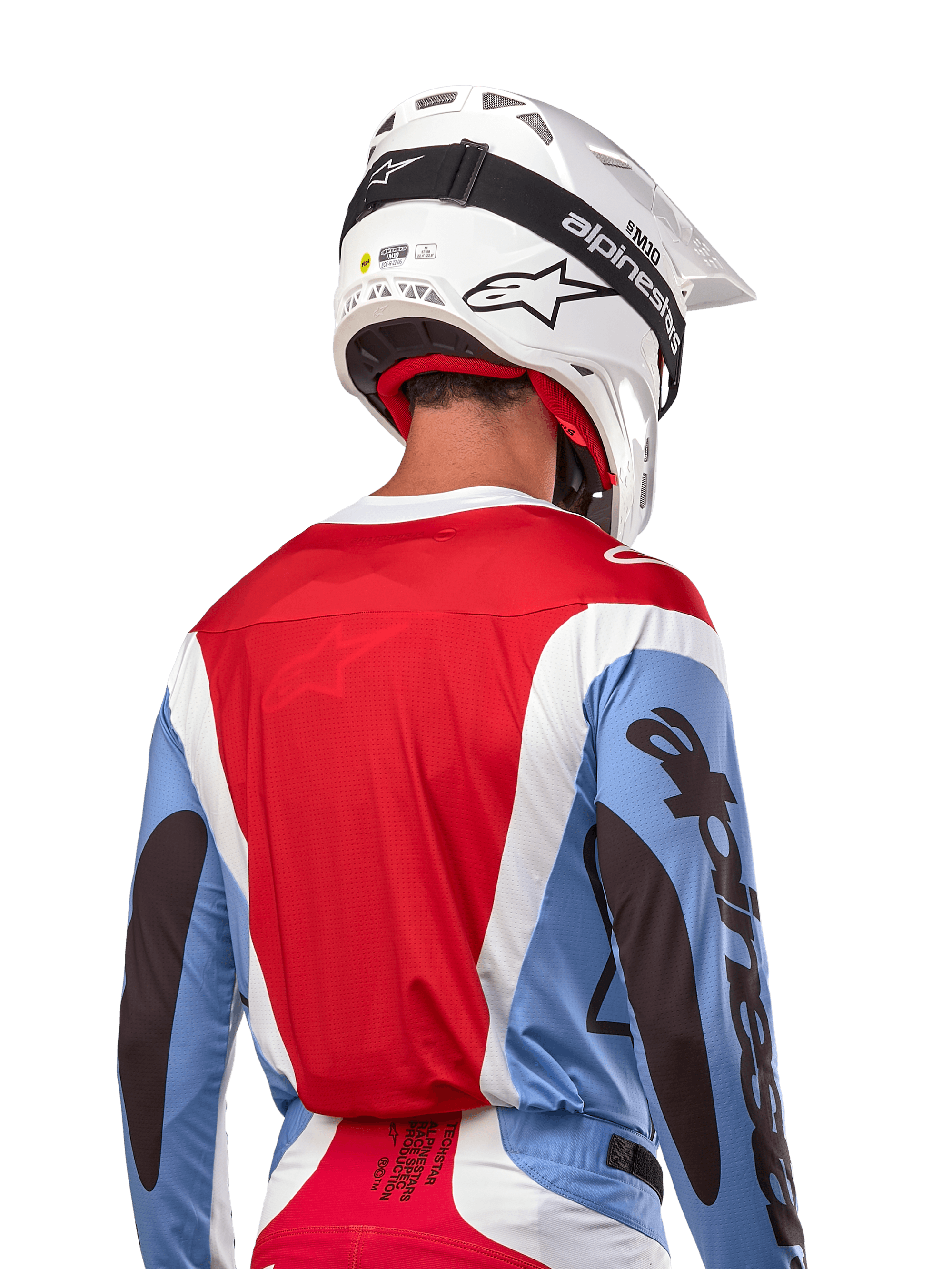 Alpinestars 2024 Techstar Ocuri Trikot, Motocross-Trikot, Hellblau, Marsrot und Weiß, Rückansicht eines Fahrers mit passendem weißem Helm und schwarzer Schutzbrille, markantes schwarzes Branding an den Ärmeln und ergonomische Race-Passform für Offroad-Performance