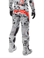 Alpinestars 2024 Techstar Rantera Hose, Motocross-Hose, Haze Gray Camo, mit schwarzen Camouflage-Mustern und einem großen roten Alpinestars-Logo auf dem Gesäß, Rückansicht getragen mit weißen Stiefeln und passender Rennausrüstung