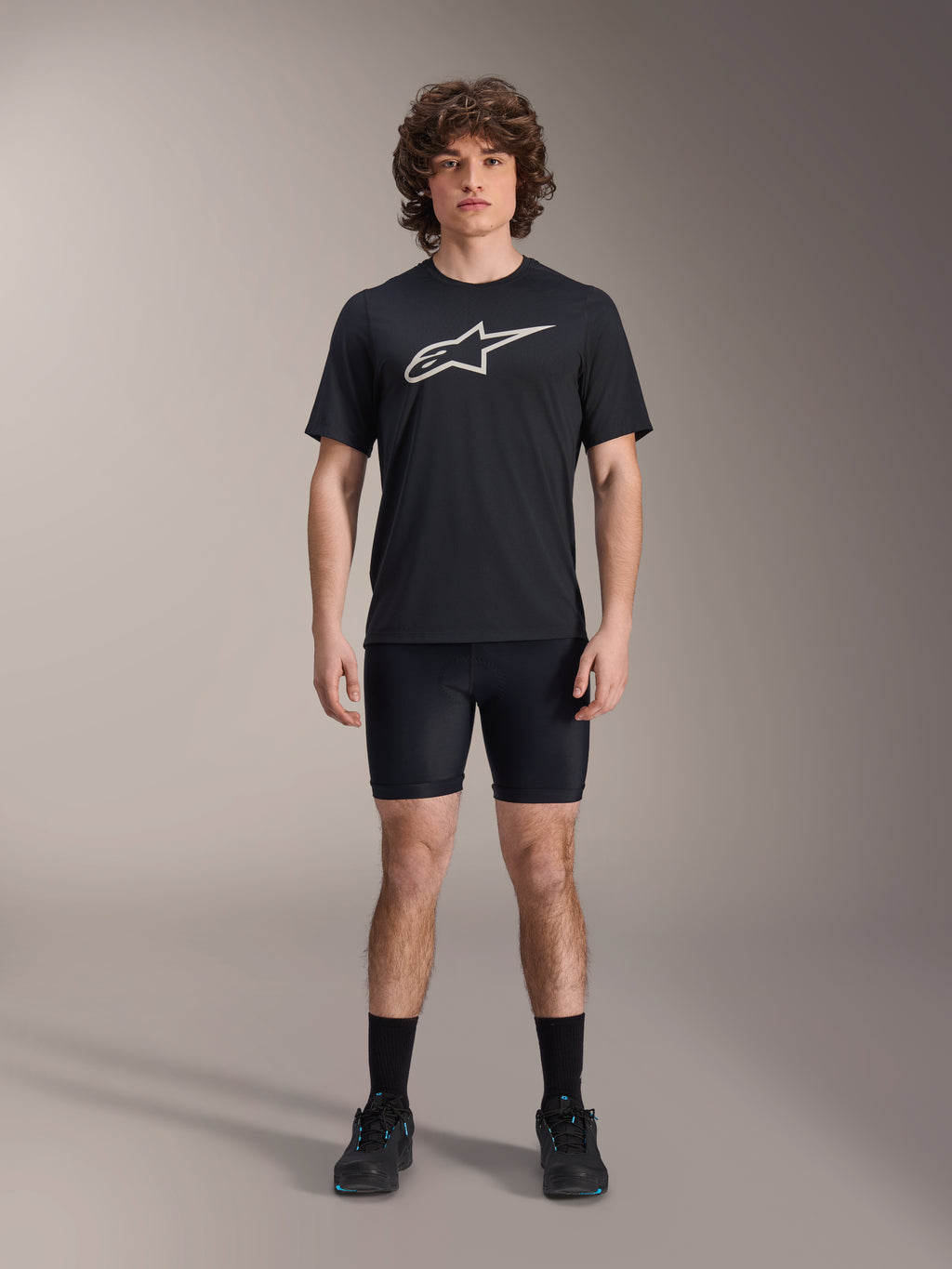 Alpinestars A-Dura Liner Shorts, schwarze Radsport-Innenhose, getragen von einem Model mit einem schwarzen Alpinestars Logo-T-Shirt und schwarzen Fahrradschuhen, eng anliegendes Design für MTB-Performance und Komfort im Sattel
