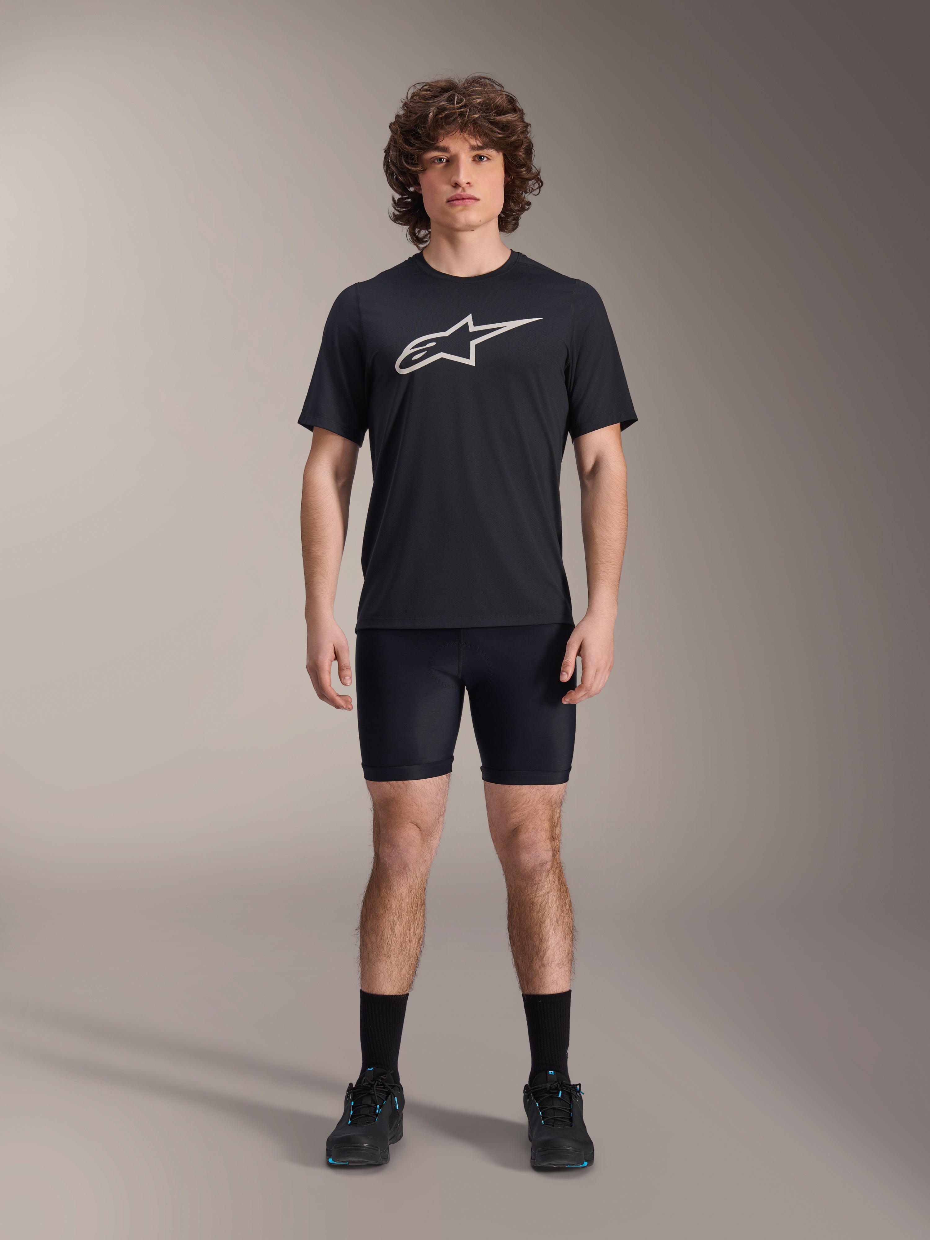 Alpinestars A-Dura Liner Shorts, schwarze Radsport-Innenhose, getragen von einem Model mit einem schwarzen Alpinestars Logo-T-Shirt und schwarzen Fahrradschuhen, eng anliegendes Design für MTB-Performance und Komfort im Sattel