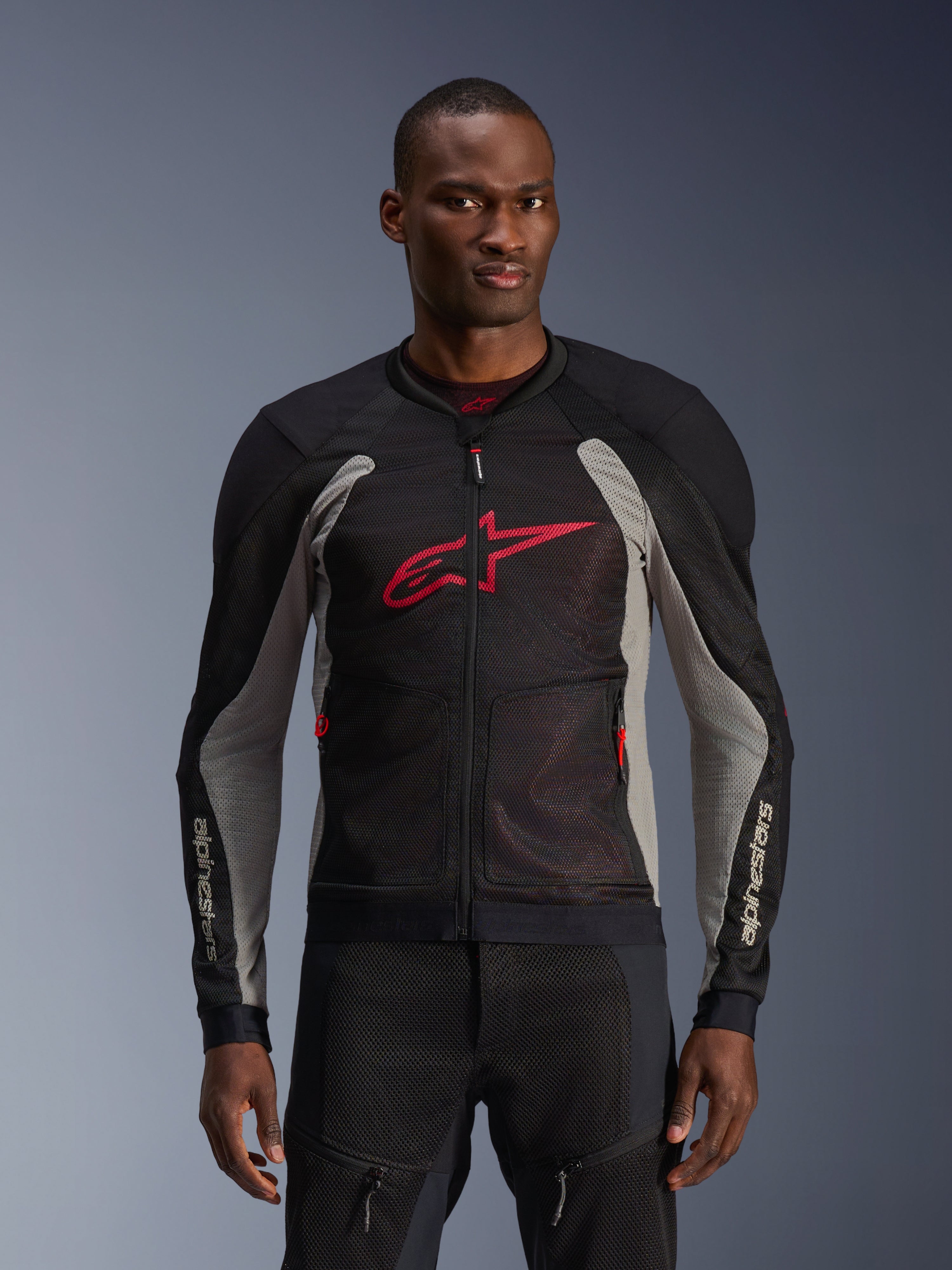 Alpinestars Troop-Air Jacket, Motorcycle Mesh Jacket, Black and Ash Gray with Bright Red accents, worn by a model, featuring breathable 2D tech mesh panels for ventilation, a large red Astars logo on the chest, and a technical sporty design for urban road riding