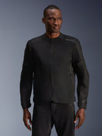 Männliches Model trägt die Alpinestars C-1 Air Jacke in Schwarz, moderne Motorradjacke mit großflächigen Tech-Mesh-Einsätzen und durchgehendem Frontreißverschluss, kombiniert mit passender schwarzer Motorradhose, urbane Lifestyle- und Pendler-Ästhetik