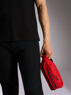 Alpinestars Only Linear Hüfttasche, Rot mit schwarzem Alpinestars-Logo und Schriftzug, von einer Person in schwarzer Freizeitkleidung gehalten, strapazierfähige Polyester-Hüfttasche für den urbanen Einsatz